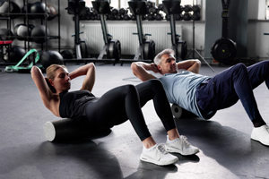 two individuals performing abdominal exercises on foam rollers in a fitness studio emphasizing core strength and wellness routines for a healthy lifestyle with effective workouts and progress at 16 repetitions