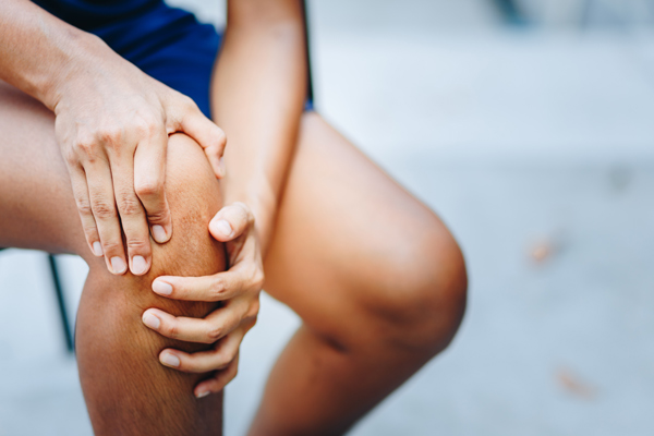 person holding knee with discomfort showcasing pain relief techniques related to health and recovery after injury or exercise for six simple steps