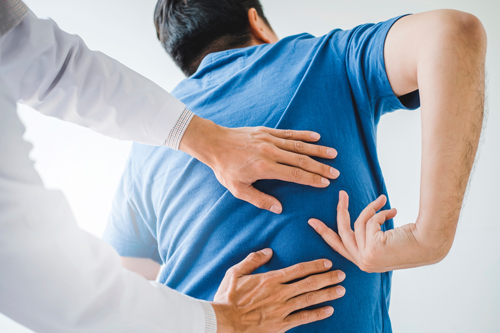a healthcare professional examining a patient's back for spinal alignment and pain relief during a chiropractic session